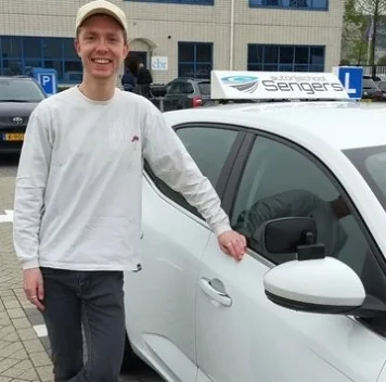 Geslaagde leerling naast de lesauto van Autorijschool Sengers